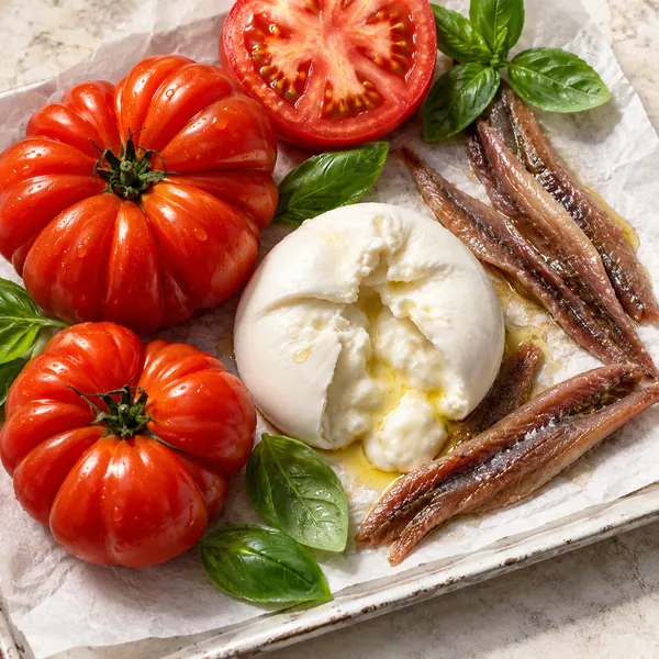 Ingredientes frescos selecionados: tomates italianos, burrata e especiarias