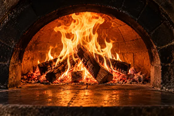 Forno a lenha artesanal com chamas e lenha em brasa